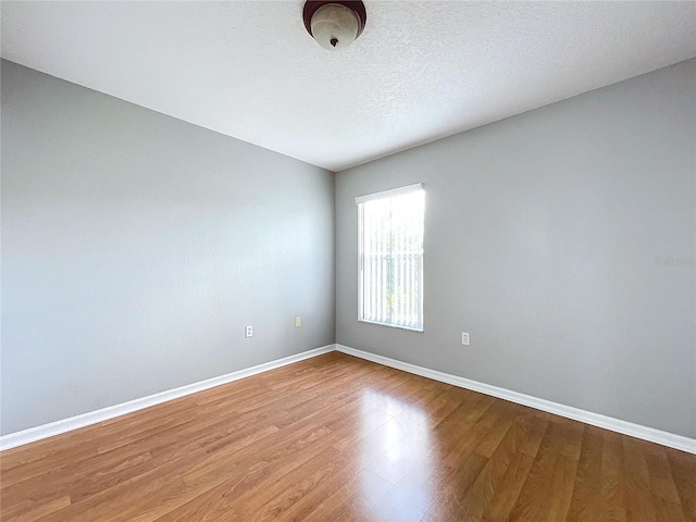 empty room featuring hardwood / wood-style floors and a textured ceiling