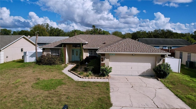 single story home with central AC, a front lawn, and a garage