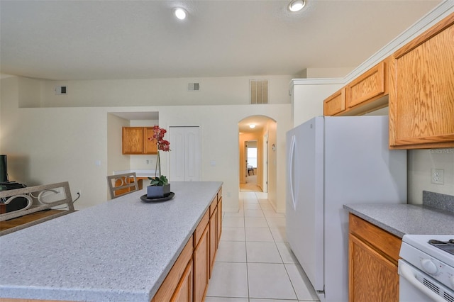 kitchen with a kitchen island, white appliances, and light tile patterned floors