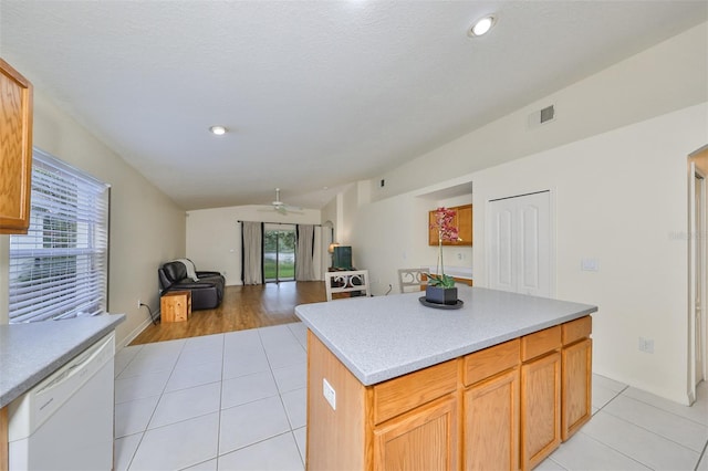 kitchen with white dishwasher, light tile patterned flooring, a kitchen island, and ceiling fan