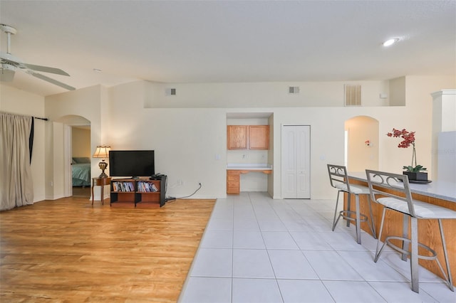 tiled living room with ceiling fan