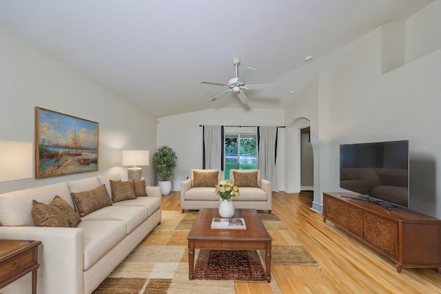 living room featuring ceiling fan, light wood-type flooring, and vaulted ceiling