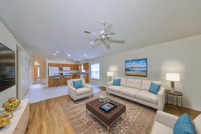 living room with light hardwood / wood-style floors, ceiling fan, and lofted ceiling