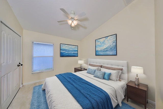 bedroom featuring lofted ceiling, light colored carpet, ceiling fan, and a closet