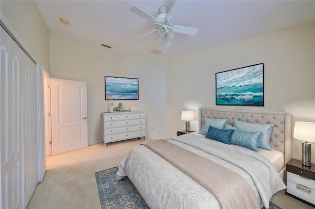 carpeted bedroom with ceiling fan and a closet