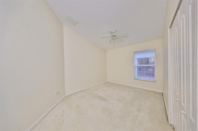 spare room featuring ceiling fan and light colored carpet