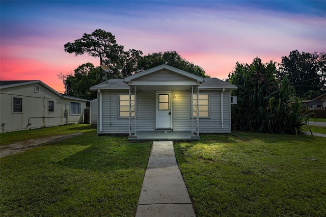 bungalow-style house with a yard and covered porch