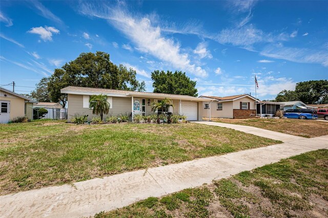 ranch-style house featuring a garage and a front lawn