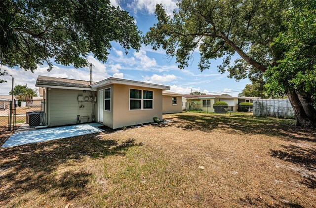 back of property featuring a patio area and a lawn