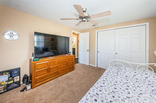 bedroom featuring ceiling fan, a textured ceiling, a closet, and carpet