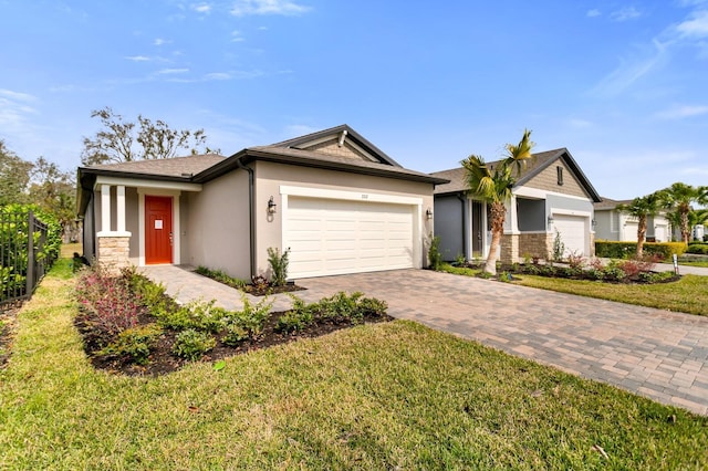 ranch-style house with an attached garage, stone siding, a front lawn, and decorative driveway