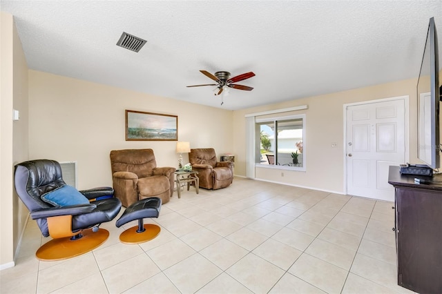 sitting room with light tile patterned flooring, ceiling fan, and a textured ceiling