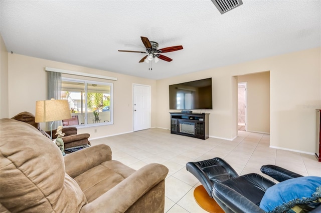 tiled living room with ceiling fan and a textured ceiling