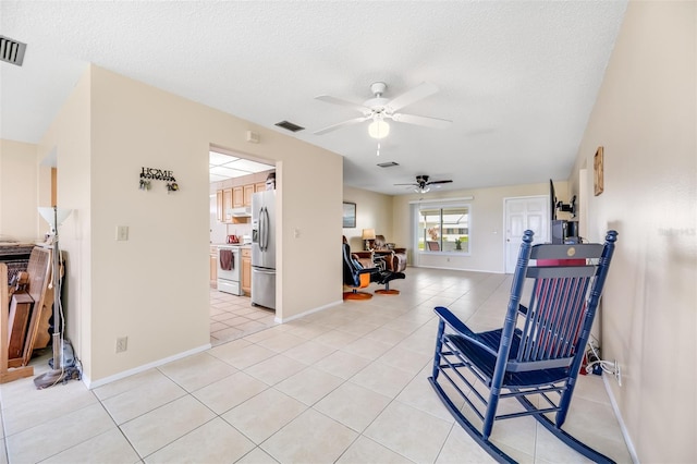 sitting room with light tile patterned floors, a textured ceiling, and ceiling fan