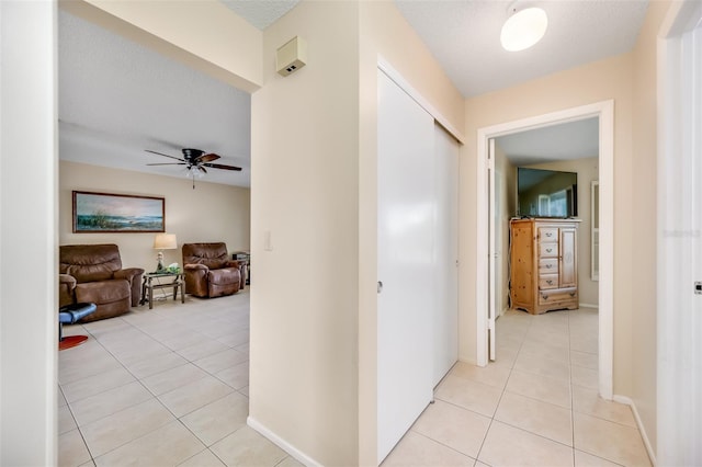 hallway with light tile patterned floors and a textured ceiling