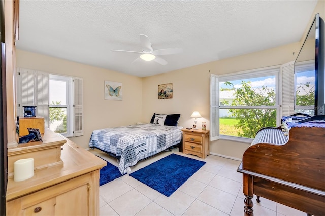 tiled bedroom with a textured ceiling and ceiling fan