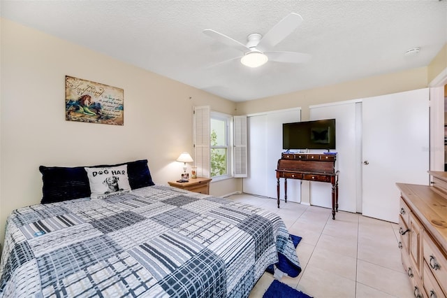 bedroom with light tile patterned flooring, a textured ceiling, and ceiling fan