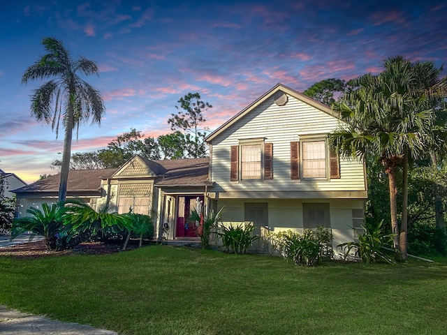 split level home featuring a front yard and stucco siding