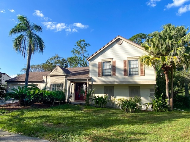 tri-level home with a front lawn and stucco siding