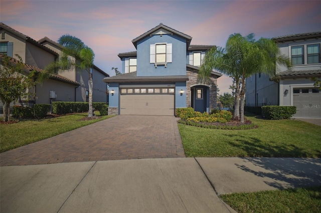 view of front of property featuring a garage and a lawn