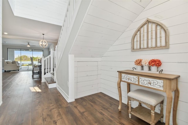 stairway with lofted ceiling, wood walls, and wood-type flooring