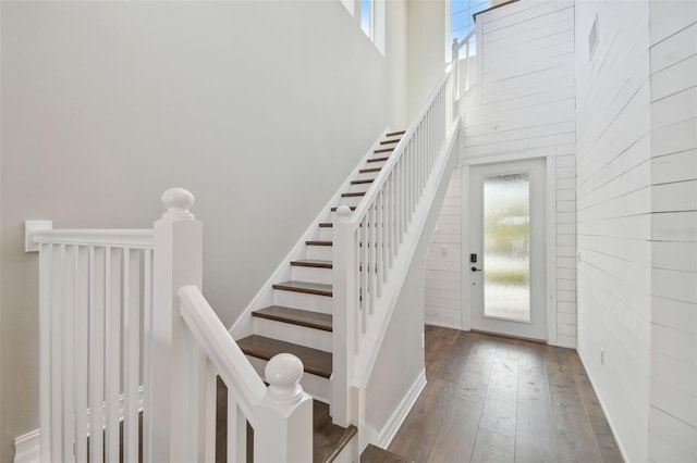 stairs featuring a high ceiling and hardwood / wood-style flooring