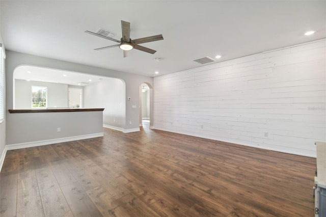 unfurnished living room with ceiling fan and dark hardwood / wood-style flooring