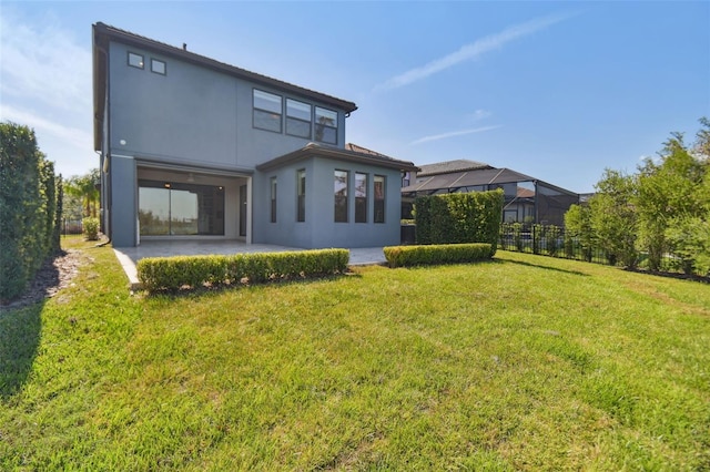 rear view of house featuring a patio and a lawn