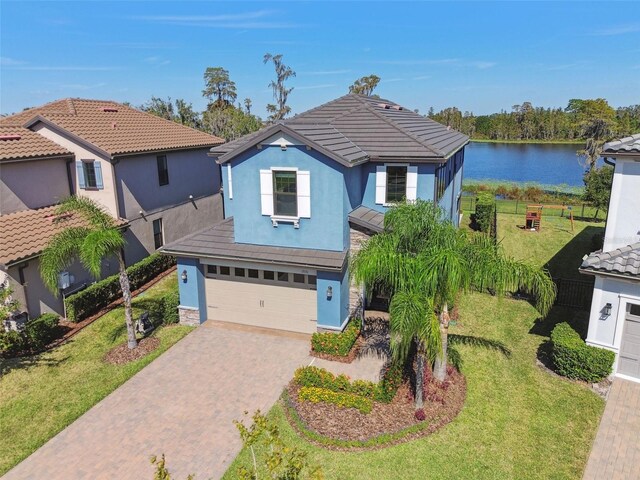 view of front of property with a water view, a front yard, and a garage