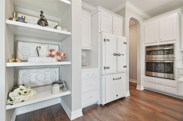 kitchen with crown molding, white cabinetry, double oven, and dark wood-type flooring