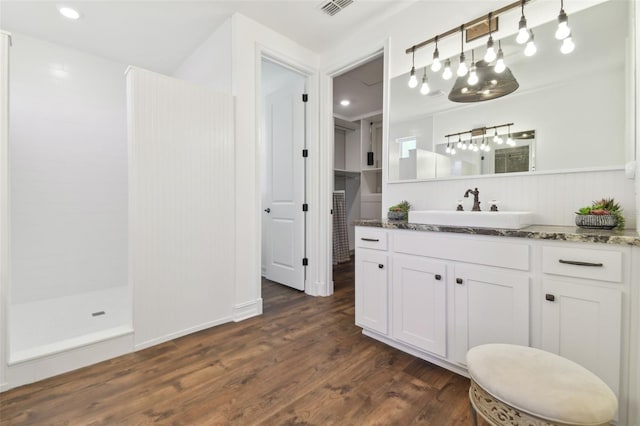 bathroom featuring vanity, wood-type flooring, and walk in shower