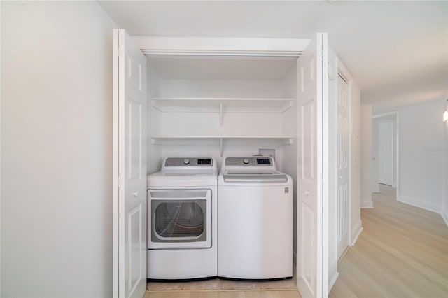 washroom with separate washer and dryer and light wood-type flooring