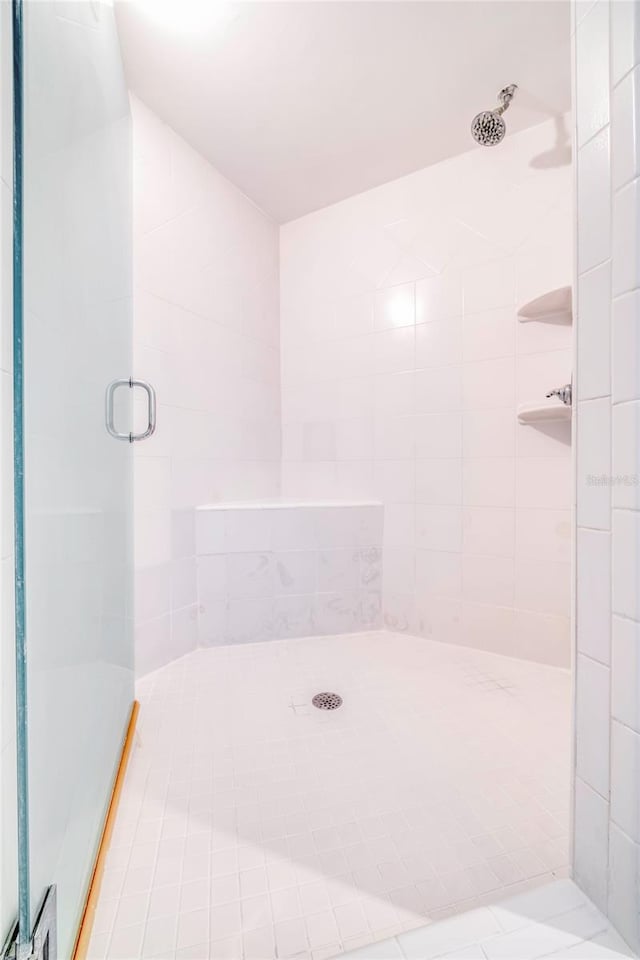 bathroom with walk in shower and tile patterned flooring