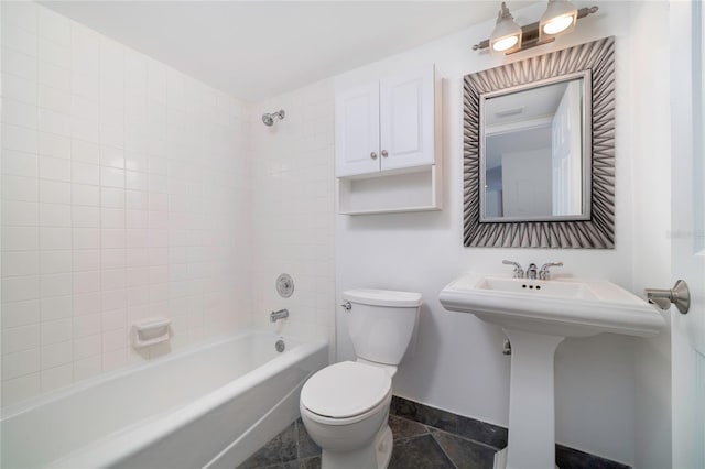 bathroom featuring toilet and tiled shower / bath