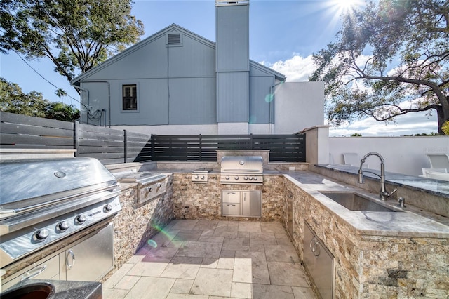 view of patio with an outdoor kitchen, sink, and area for grilling