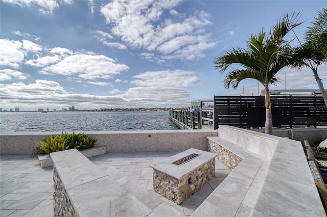 view of patio / terrace featuring a water view and a fire pit