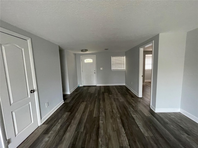 hallway featuring a textured ceiling and dark hardwood / wood-style floors