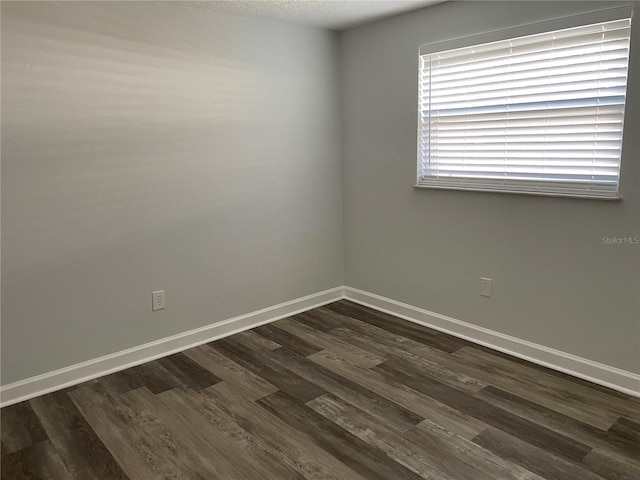 empty room featuring dark hardwood / wood-style flooring and a textured ceiling