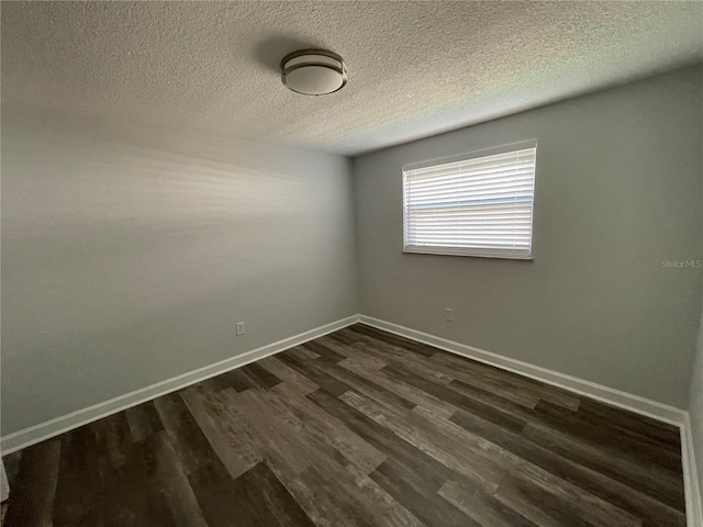 unfurnished room featuring a textured ceiling and dark hardwood / wood-style floors