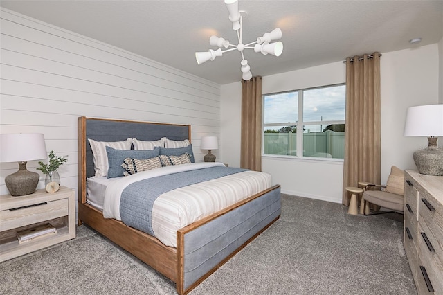 carpeted bedroom featuring wooden walls, a notable chandelier, and a textured ceiling