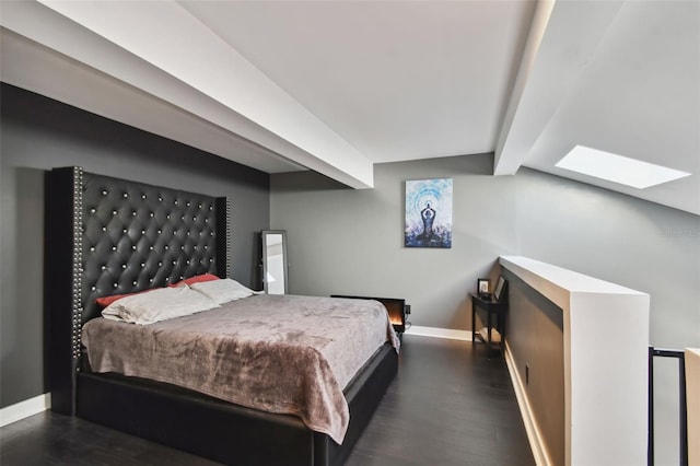 bedroom with lofted ceiling with skylight and dark hardwood / wood-style flooring