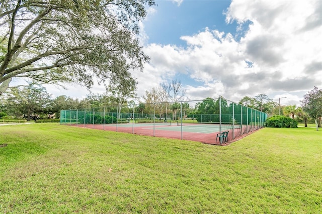 view of tennis court with a lawn