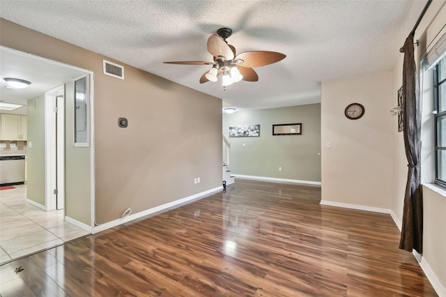 unfurnished room with hardwood / wood-style floors, ceiling fan, and a textured ceiling