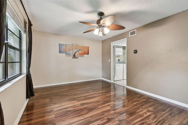 unfurnished room with ceiling fan, separate washer and dryer, a textured ceiling, and dark hardwood / wood-style flooring