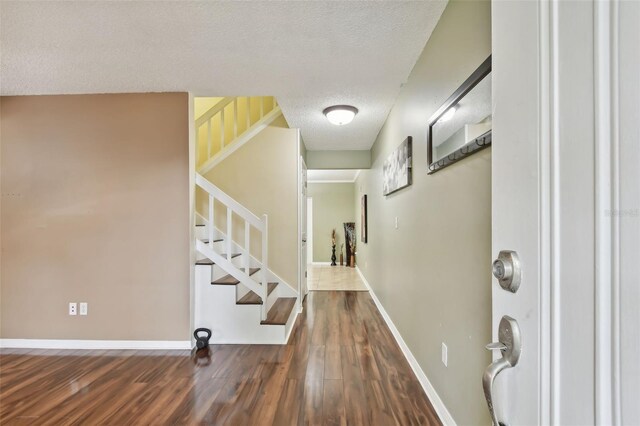 entrance foyer featuring dark hardwood / wood-style flooring and a textured ceiling