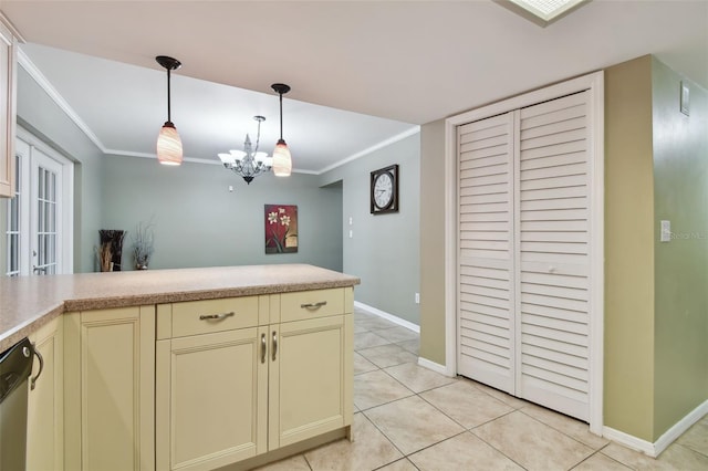 kitchen with ornamental molding, a notable chandelier, cream cabinets, and light tile patterned floors