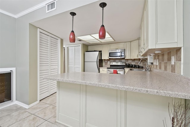 kitchen with stainless steel appliances, decorative light fixtures, and kitchen peninsula