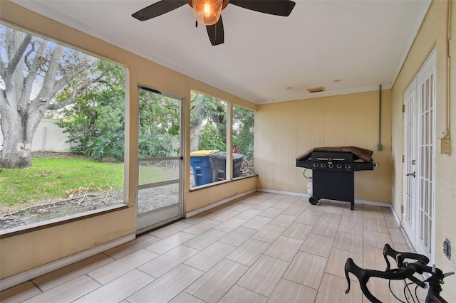 unfurnished sunroom with ceiling fan and a healthy amount of sunlight