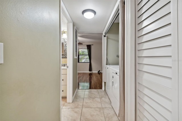 hallway featuring light tile patterned floors and washing machine and clothes dryer