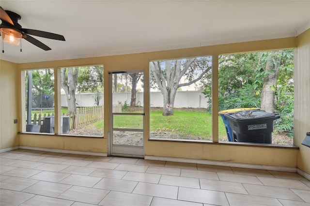 unfurnished sunroom with ceiling fan